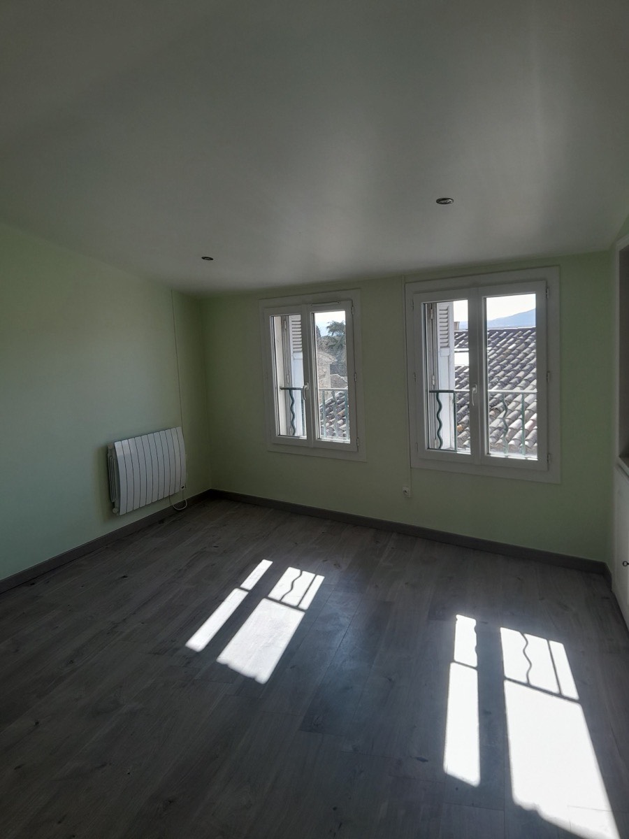 Chambre peinte en vert d'eau avec parquet et fenêtres sur les toits